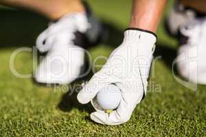 Cropped image of man placing golf ball on tee