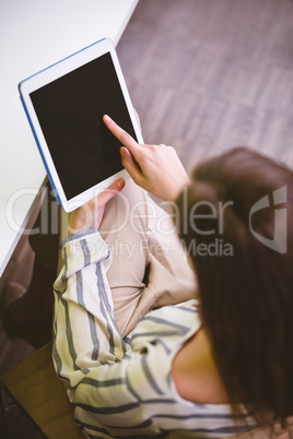 High angle view of executive touching tablet screen at office