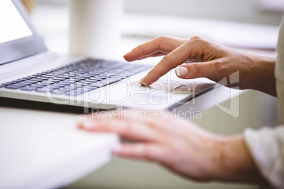 Cropped image of businesswoman using laptop at office