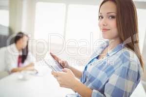 Portrait of businesswoman using digital tablet at creative offic