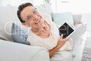 Portrait of smiling mature woman holding digital tablet