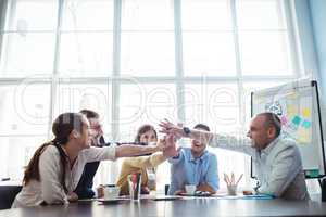 Colleagues high-five in meeting room