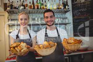 Portrait of confident workers with fresh bread in baskets