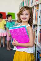 Cute girl holding books in school library
