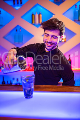 Bartender pouring cocktail in glass