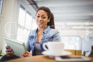 Portrait of businesswoman holding digital tablet in office