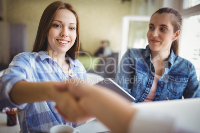 Businesswomen shaking hands in creative office