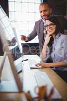 Businesswoman with male colleague at computer desk