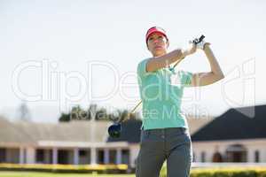 Low angle view of golfer woman taking shot