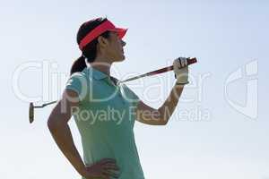 Low angle view of woman carrying golf club