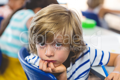 Portrait of serious boy with classmates