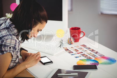 Woman using mobile phone in creative ffice