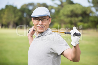 Side view of confident man holding golf club