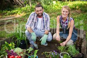 Portrait of happy gardeners with potted plants at garden