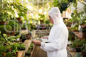 Male scientist in clean suit using laptop