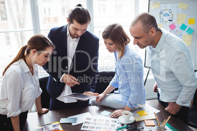 Photo editors using digital tablet in meeting room