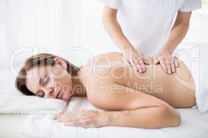 Masseur giving back massage to woman