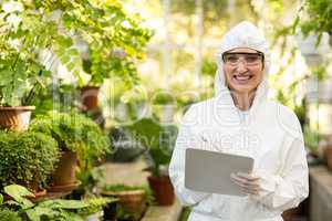 Female scientist smiling while writing on clipboard