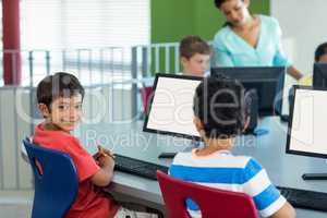 Boy with classmates and teacher during computer class