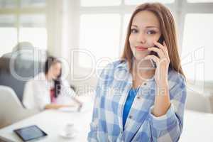 Portrait of businesswoman using mobile phone at creative office