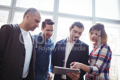Businessman showing digital tablet to coworkers