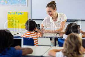 Teacher showing digital tablet to boy