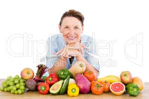 Portrait of smiling woman with fruits and vegetables at table