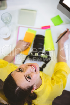 Portrait of happy photo editor sitting at office