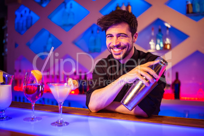 Bartender smiling while holding cocktail shaker