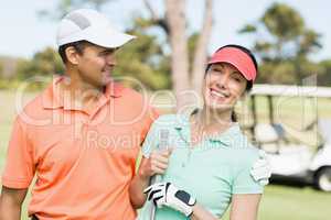 Smart golfer couple with arm around