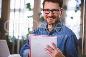 Portrait of happy executive with documents at office