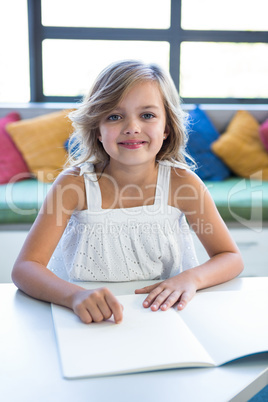 Smiling girl studying in school library