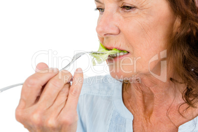 Close-up of mature woman eating vegetable salad