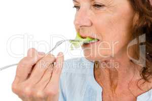 Close-up of mature woman eating vegetable salad