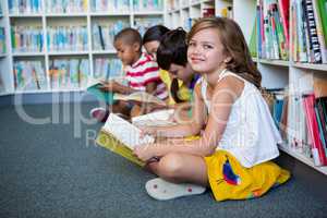 Happy students sitting at library in school