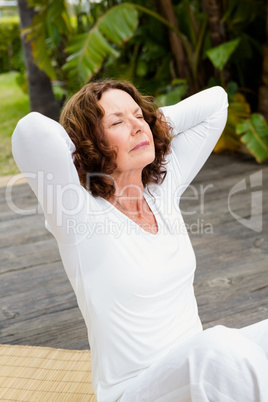 Woman with hands behind head while doing yoga