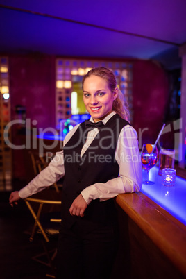 Beautiful bartender leaning at bar counter