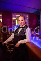 Beautiful bartender leaning at bar counter