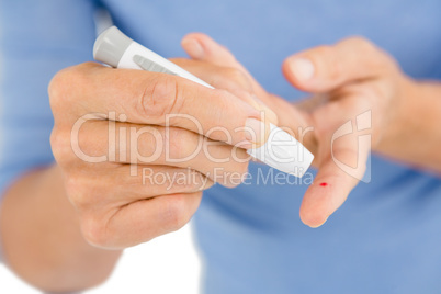 Woman using blood glucose monitor