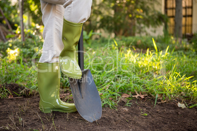Low section of female gardener with shovel at garden