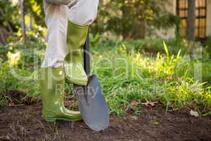 Low section of female gardener with shovel at garden