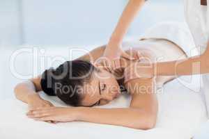 Relaxed naked woman receiving back massage