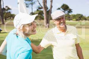 Happy golfer couple with white flag