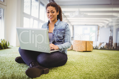 Portait of businesswoman working with laptop in creative office