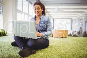 Portait of businesswoman working with laptop in creative office
