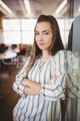 Confident businesswoman with arms crossed in office cafeteria