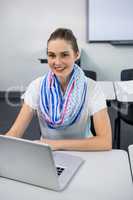 Portrait of teacher using laptop in classroom