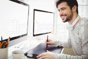 Businessman using graphics tablet in front of computers
