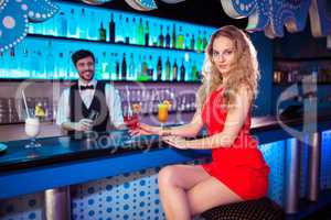 Attractive woman sitting by counter in night club