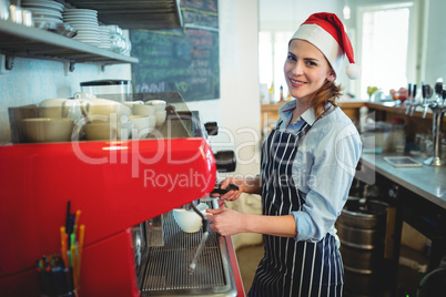 Portrait of happy waitress wearing Santa hat at cafe